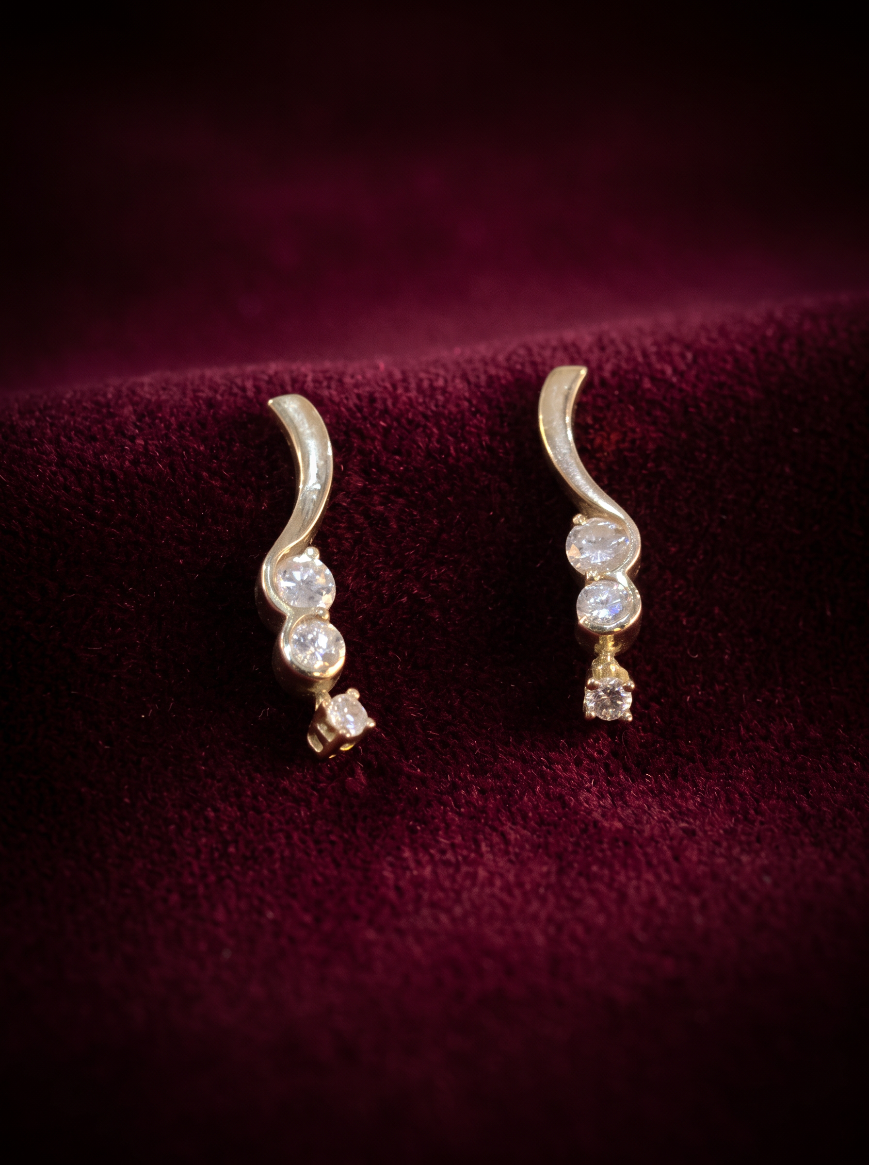A pair of gold wave earrings set with diamonds, made at our bench